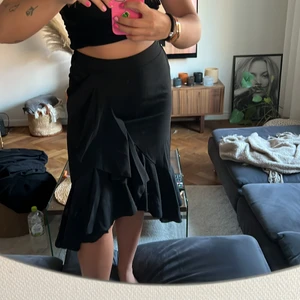 Kjol med volang  - En svart kjol med volanger i strl M! Resår baktill och dragkedja i sidan, den är aldrig använd! 💗💗