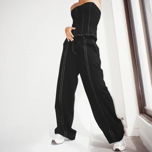 Kostymbyxor med vita streck  - Säljer dessa super snygga kostysmbyxor i storlek M från motelrocks. Helt oanvända med prislappen kvar. Jag beställde dessa i två storlekar, men valde att behålla den mindre storleken.  Orginalpris: 550kr. Fraktkostnaden tillkommer🥰