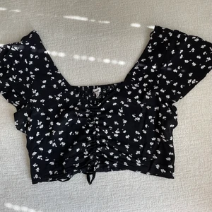 Blommig topp - Jättefin blommig topp som endast använts ca 1-2 ggr, köpt i usa från märket Garage, säljer också en tillhörande kjol💕 Ryschad i mitten med knytdetalj🫶🏼o