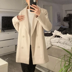 Beige kappa. - Slutsåld på hemsidan, i ett bra sick. 