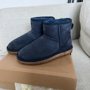 Ugg storlek 36 blåa  - UGGS mini blå i storlek 36. Endast använda 2 gånger och är i mycket fint skick, tecken på användning finns på sulan som bild visar, ej creasade! Finns att hämtas i centrala Göteborg annars står köparen för frakt på 66kr spårbart med postnord.
