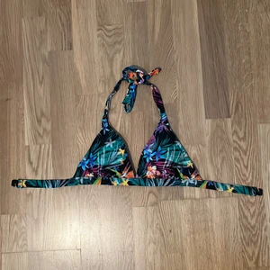 Blommig bikinitopp - En sommrig bikinitop från Stadium som man knyter själv bakom nacken! 🌸☀️ Använd 3-4 gånger eftersom jag har andra bikinis som jag använder mer. Den är triangelformad och har en diskret och lättstängd knäppning på baksidan (se bild 3). Frakt tillkommer.