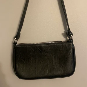 Väska  - Svart mindre fejk skinn imitation väska med silver kedja. 