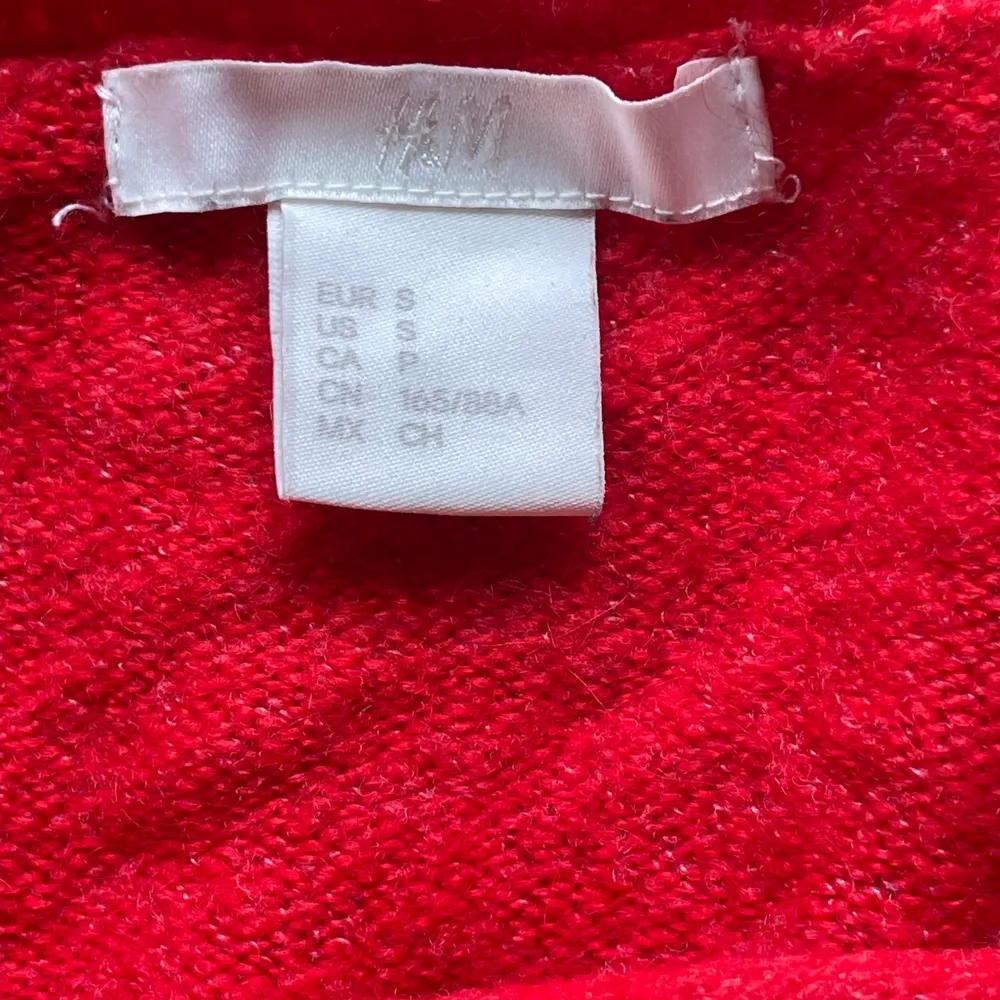 En röd stickad tröja med pärlor på i storlek S ifrån HM. Sitter lite lösare. Fler bilder kan fås och kan skicka! Längd: 53 cm. Stickat.