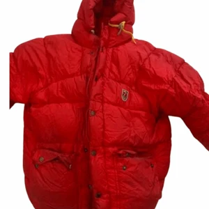 Fjällräven jacka  - En röd fjällräven jacka i storlek small. Inköpt 2009 och är större i storleken än vad dom är idag. Jackans dragkedja är lite sönder men ingenting som påverkar och finns även en del mörkare fläckar som är svåra att ta bort på jackans baksida. 