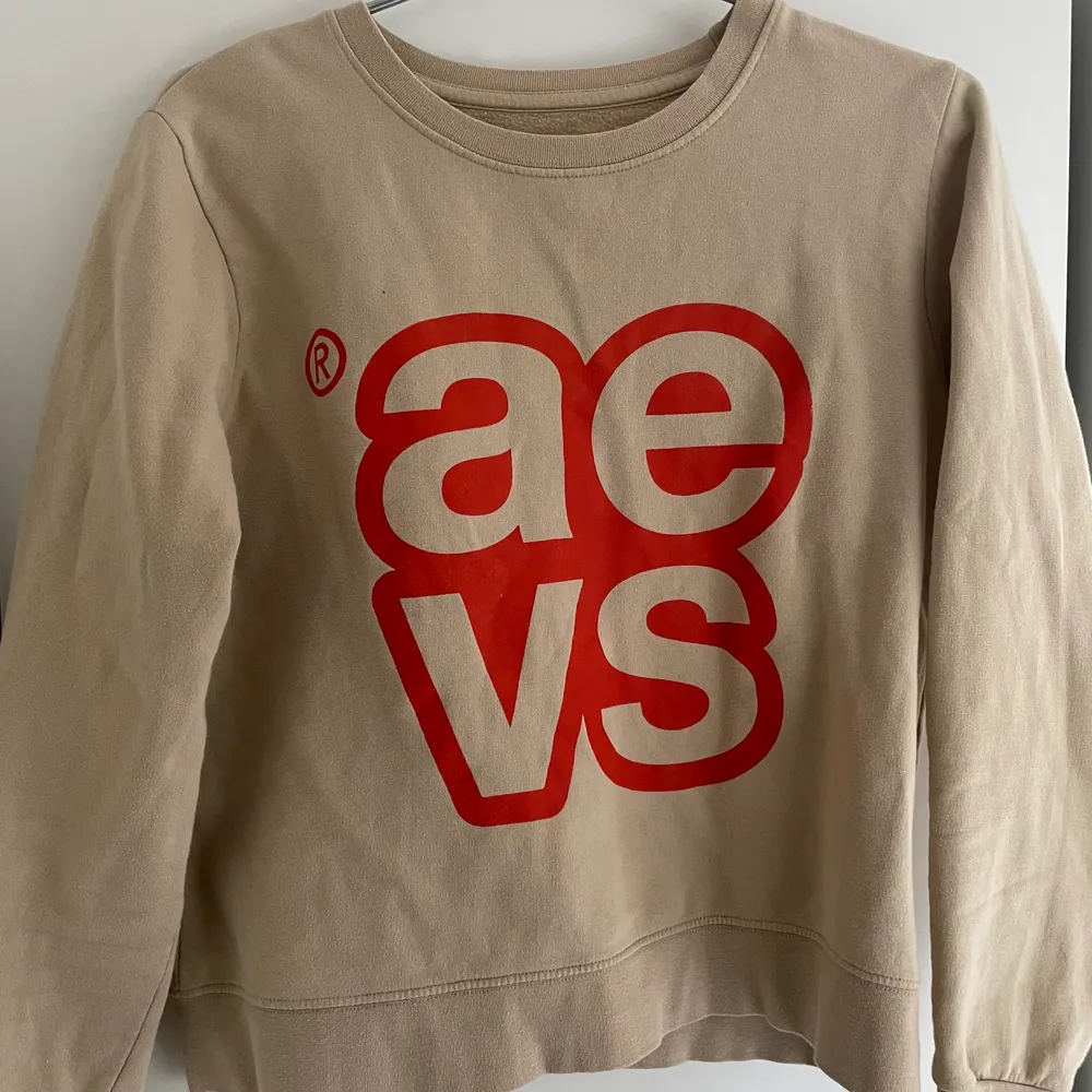 Jättefin sweatshirt från märket Svea. Beige med röd text. Säljes i befintligt skick. Strl xs och säljes för att den nu är för liten på mig!. Tröjor & Koftor.