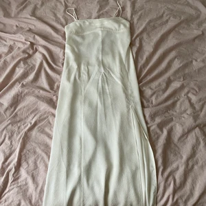 Vit klänning - Vit lång klänning perfekt för stundenten från H&M. Den har öppen rygg och sitter jättefint, jag är 165 cm och den går ner till anklarna. Jag köpte för att prova men det har gått för länge för att returnera så jag säljer den nu! Lapparna sitter kvar. Köparen står för frakt💖