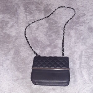 Liten väska - Svart läder väska med ett axelband sammt ett fack innuti väskan ,bra att ha på stan eller ngt ,magnetisk knapp som håller ihop väskan, bara andvänt den en gång obs inga skador på väskan.