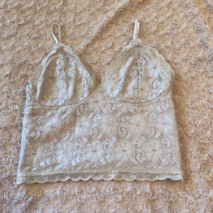 BIKBOK - Ett linne i beiget som har spets detaljer