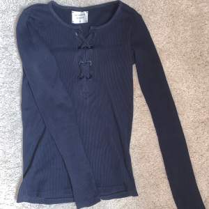 En marinblå långärmad tröja med knytning upptill. Den passar som storlek S och är använd fåtal gånger och är i nyskick.