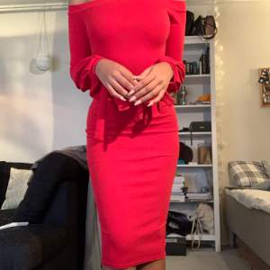 En klar röd bodycon klänning som är off the shoulder och har rosetter på slutet av ärmarna. Enbart använd 2 gånger. Klänningen är från märket BOOHOO och är storlek 36. Fin kvalite och bra för fest eller event.