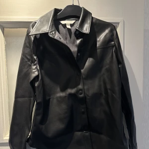 Skjorta  - Svart skjorta från H&M. Aldrig använd, varit nerpackad sedan den köptes, då den ej passa mig. Storlek 36