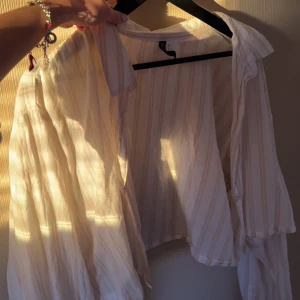 Croppad skjorta  - liten skjorta i Strl L, passar mig som är XS/S! Går att styla på olika sätt, väldigt croppad! Genomskinlig så ett linne krävs under ifall man vill ha den knäppt! Använd fåtal gånger 💛 skriv vid frågor