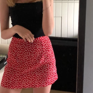 Blommmig röd minikjol - Jättesöt tunn blommig minikjol. Säljes på grund av att den blivit för liten :(