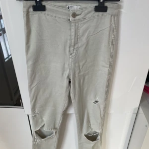 Beige jeans med hål på knäna - Beige långa  jeans med hål på knäna. Gina tricot perfect jeans storlek M