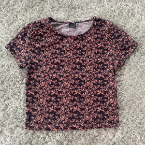 T-shirt/topp från Ginatricot strl.S - Blommig T-shirt i rosa och marinblå/svart i bra skick.  