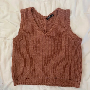 Stickad topp - Stickad topp i en kopparbrun färg med en liten öppning i ryggen. Passar XS/S