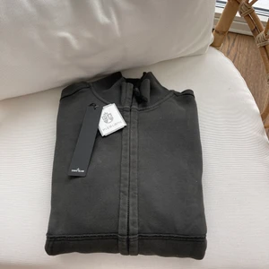 Stone Island - Säljer nu min Stone Island tröja med zip och krage. Tröjan är så gott som ny och näst intill oanvänd. Skick 9/10. Storlek M. Nypris 220€ mitt pris 1399kr