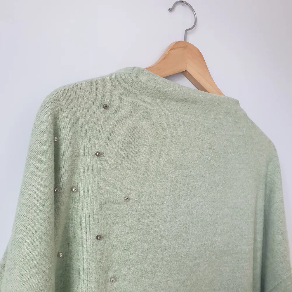 En mysig tröja med prydnadspärlor. Nytt skick, aldrig använd. Rak i nacken. Mintgrön, lite längre i bak. Storlek XL 96% polyester och 4% elastan.. Neuleet.