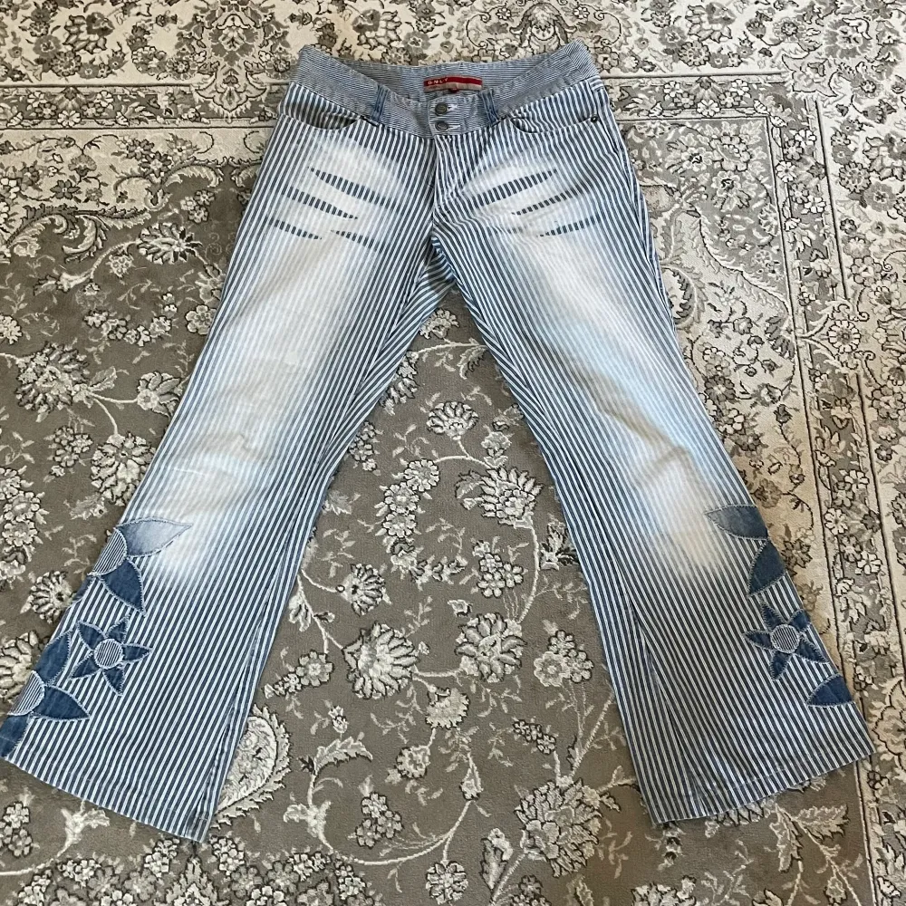 INTRESSEKOLL! På mina favorit byxor som tyvärr börjar bli för små. Superfina randiga jeans med patchwork detaljer i form av blommor. Sköna och i väldigt bra kvalité (inga fläckar, noppror eller hål). Vid intresse startar jag budgivning exklusive frak 🥰. Jeans & Byxor.