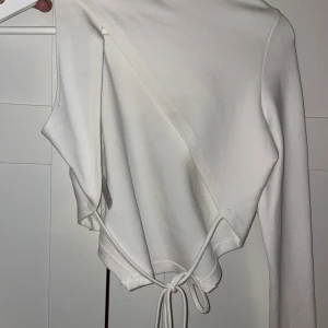 Vit topp från Angelica Blicks kollektion - Vit topp från NA-KD, använd en gång. Superfin topp med öppenrygg och bara en ärm! Fin till sommarn 🌸