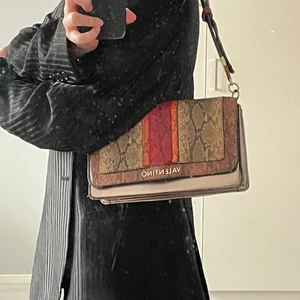 Valentino väska - Så fin och unik valentino-väska i ormskinn. Brett justerbarbart band. Använd men väldigt fint skick.