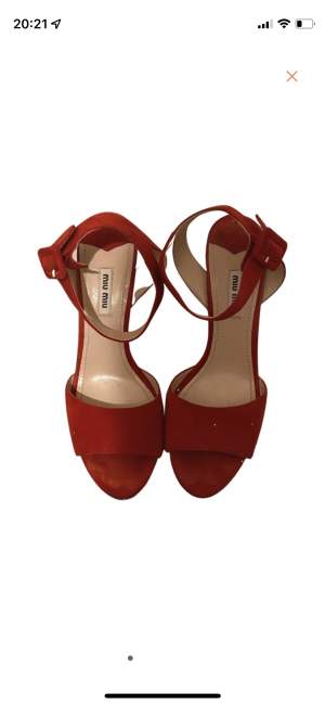 Red sandals with platform heels covered in gold glitter. Small sign of wear on one heel.