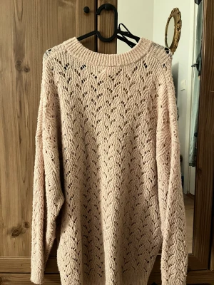 Rosa stickad tröja - En rosa stickad tröja med ”öppna hål”. Super mysig och stor, passar med ett vitt linne eller bralette under! 