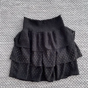 Kjol Saint Tropez - Fin volangkjol med guldiga detaljer från märket Saint Tropez. Går lite länge mer än till mitten av låten på mig som är 168 cm. Köparen står för kostnader som tillkommer.