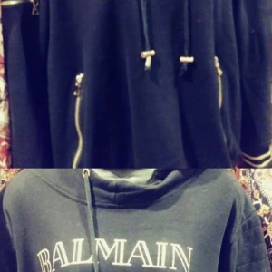 Balmain Black And Gold Hoodie Unisex - Helt fräsch använt 1 gång Balmain Hoodie köpt i Dubai Mall och har kvitto. Köpt för nästan 4.000 kronor  Bilden är ganska dålig men live den är mkt finare