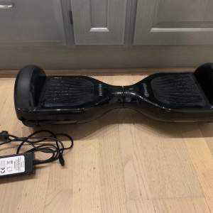 En svart stilren Hoverboard perfekt för julklapp eller present. Denna fungerar perfekt endast minimala slitager på utsidan. Laddare medföljer, köpt för 2000kr och denna kan man även köra med utomhus.