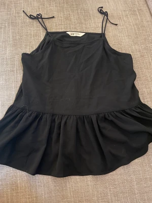 svart volangtopp - säljer så fin svart volangtopp som inte kommer till användning längre! passar bra både i sommar och på fest! köptes för ca 100kr och jag säljer för 60kr+frakt🖤