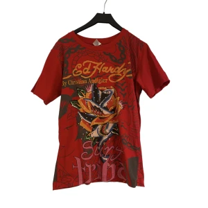 Ed Hardy t-shirt - T-shirt från Ed-Hardy. Bra skick förutom en liten reva i ena armhålan (se bild 3). Strl M men skullesäga att den är relativt liten i storleken.