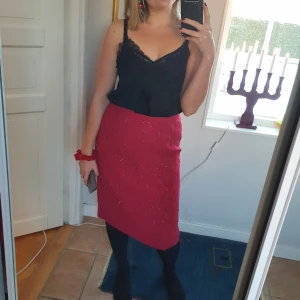 Vintage Röd Pennkjol - Röd pennkjol perfekt till julfirande! Storlek M. Köpt på vintage-butik i Paris. Den är figursydd med dragkedja och knapp i bak. Paljetter i mönster på hela tyget. Jag är 168cm lång och kjolen går strax över knät