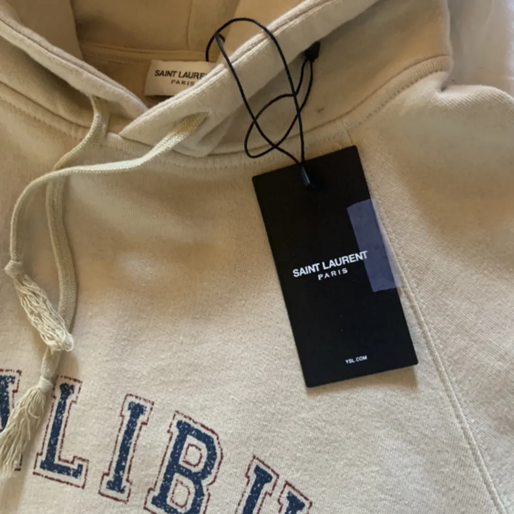 Riktigt snygg Saint Laurent hoodie, köpt i Italien för ca 3 månader sen. Nypris på tröjan ligger på ca 7000 kr. Tröjan är använd men är nästan i nyskick.. Tröjor & Koftor.