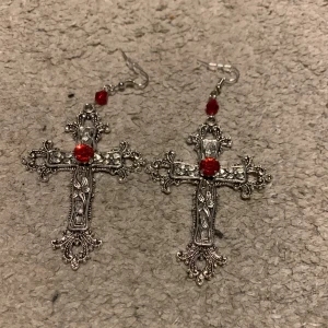 Y2k gothic örhängen  - Mellanstora kors örhängen med röd sten. Aldrig använda. Jättefina små detaljer. (Inte rostiga alls)