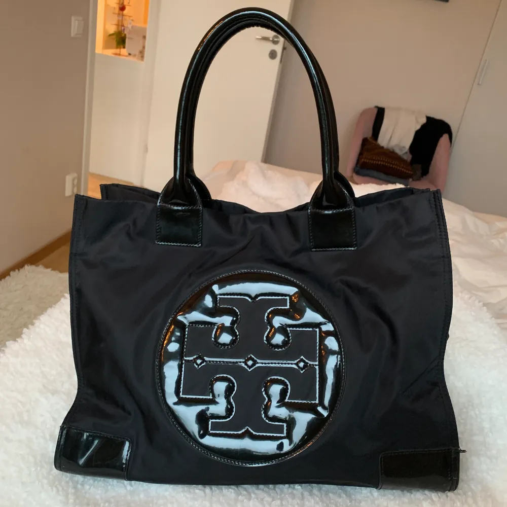 Svart Tory burch shopper/tote väska i nylon och läderdetaljer.  längd:42 bredd:17cm höjd:30 Nypris ca 3000kr. Väskor.