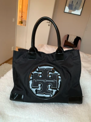 Tory Burch väska - Svart Tory burch shopper/tote väska i nylon och läderdetaljer.  längd:42 bredd:17cm höjd:30 Nypris ca 3000kr