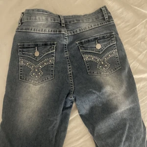Jeans med detaljer på bakfickorna - Säljer dessa jeans då de är lite för små för mig i midjan, skit snygga detaljer på bakfickorna. Köptes second hand så vet ej var de är ifrån. Storlek 36/38, Är 169 lång!!:)🫶🏼🫶🏼De är midwaist