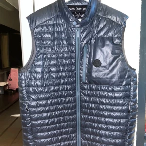  MONCLER VÄST - Tja, köpte Moncler väst i marbella för 6000kr men den har inte kommit så mycket till användning då den är i storlek L. Den har inga håll eller något inga fel på den priset är inte hugget i sten. 