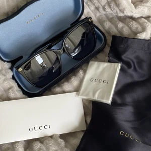 Gucci solglasögon - Helt oanvända solglasögon från Gucci, allt är kvar (dustbag, cleaning cloth, fodralet, certification). Fick i examenspresent men har för smalt ansikte.. Bågbredden är 142mm. Originalpris 2000kr