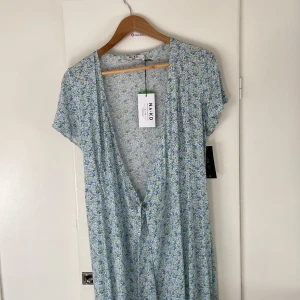 Klänning  - Oanvänd ny klänning från NA-KD, knyter i midjan, jättefin men kommer inte till användning