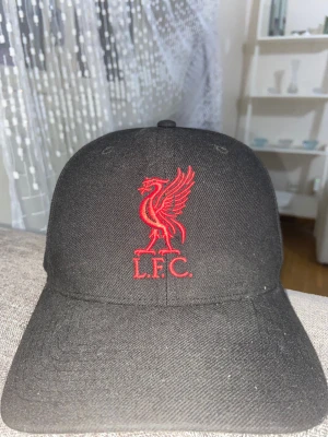 En Liverpool keps  - Det är en röd och svart Liverpool .Den är inte använt så mycke runt tre gånger. 