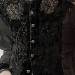 Långärmad indie/hippie tröja/kofta med broderade blommor och sammet.  Den är luftig och har knappar. Storlek står inte på gissar M/L
