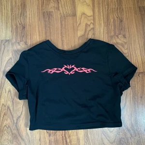 Cropped tee med hjärta - En cropped tee med ett hjärta i mitten. Har aldrig använt eftersom den är inte min stil🖤 Skriv för mer bilder!