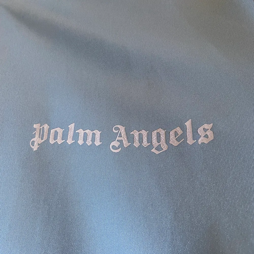 Palm angels tracksuit överdel. Condition 7/10. Råkade tvätta den i torktumlaren vilket man inte skulle så att märket på framsidan blev luddigt (3dje bild). Blixtlåsöppnaren lite flawed (skriv för bild). Annars inga synliga fel.. Tröjor & Koftor.