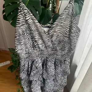 Sjukt söt klänning i zebra mönster från Gina Tricot. Har volanger på kjolen. Storlek 40, använd 1-2 gånger. Resår i midjan och axelbanden går att justera! Säljer för 100kr