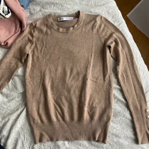 Stickad tröja - Beige tunt stickad tröja med knappar på ärmarna från zara. Den har tyvärr blivit för liten för mig. Fint skick och passar till mycket. Säljer likadan i svart.