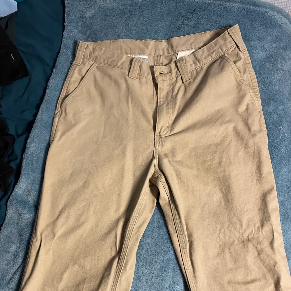 Säljer dessa carharrt carpenter pants, i matt beige. De är storlek 34/34 men sitter ganska bra på mig som brukar ha 32/32. Finns en liten svart fläck på baksidan (andra bilden) annars bra skick. Bud tas emot, men köparen står för frakt.. Jeans & Byxor.