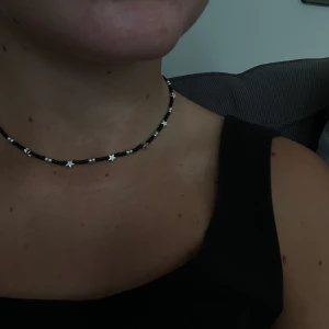 Star night  - Super fint halsband gjort av svarta och silvriga pärlor blandat med små stjärnor. Halsbandet är mellan 35-40cm. Det ingår spänne och ringödlor så man kan justera halsbandet. Obs frakten kostar 15kr